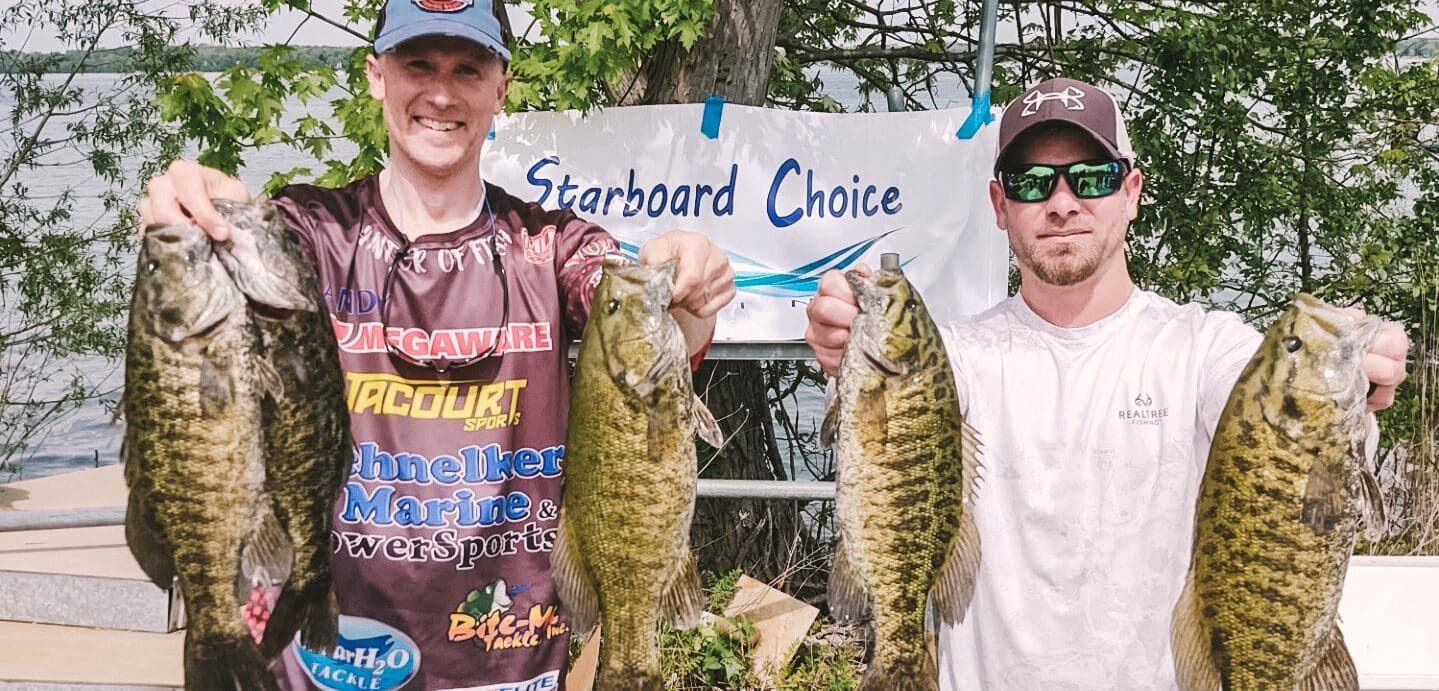 anglers holding up smallmouth bass at fishing tournament
